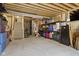 Unfinished basement with exposed ceiling and concrete floor, with storage shelves and stairs at 3424 S Lookout Pass, New Palestine, IN 46163