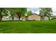 Lush green backyard featuring a manicured lawn and detached outbuildings at 35 Meadow Dr, New Palestine, IN 46163