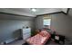 Cozy bedroom with grey walls, large window, and a brightly patterned bed at 35 Meadow Dr, New Palestine, IN 46163