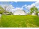 Large backyard with lush green lawn and white siding of the home at 3846 Alsace Pl, Indianapolis, IN 46226