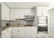 Bright kitchen features white cabinets, stainless appliances, and mosaic backsplash at 3846 Alsace Pl, Indianapolis, IN 46226