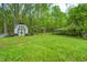 View of a house and a shed on a beautiful green lawn surrounded by lush trees at 4080 S London Dr, Martinsville, IN 46151