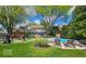 Spacious backyard with a pool, lounge chairs, and mature trees, perfect for outdoor entertaining and relaxation at 4619 Allen Dr, Carmel, IN 46033