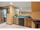 Basement bar area featuring a mini-fridge, sink, mirrored backsplash, and wood cabinets at 4619 Allen Dr, Carmel, IN 46033