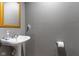 Modern half bathroom featuring a pedestal sink, framed mirror, and gray walls at 4619 Allen Dr, Carmel, IN 46033