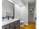 Well-lit bathroom featuring a gray vanity, white countertop, and hardwood floors, providing a clean and modern aesthetic at 4619 Allen Dr, Carmel, IN 46033