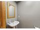 Powder room with a pedestal sink, gray walls, gold mirror, and wood trim at 4619 Allen Dr, Carmel, IN 46033