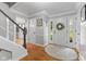 Bright foyer with hardwood floors, white trim, and a staircase with black handrail at 4619 Allen Dr, Carmel, IN 46033