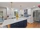 Bright kitchen with white cabinets, a blue island, modern appliances, and hardwood floors, perfect for cooking and entertaining at 4619 Allen Dr, Carmel, IN 46033