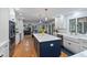 Modern kitchen featuring white cabinets, stainless steel appliances, a large island, and hardwood floors at 4619 Allen Dr, Carmel, IN 46033