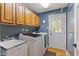 Functional laundry room features ample cabinet space, modern machines, and convenient outdoor access at 4619 Allen Dr, Carmel, IN 46033