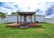 Lush backyard features a gazebo with wooden deck, fire pit, and expansive lawn for outdoor enjoyment at 4632 Willowbrook Dr, Columbus, IN 47203