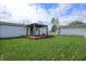 Lush backyard features a gazebo with wooden deck, fire pit, and expansive lawn for outdoor enjoyment at 4632 Willowbrook Dr, Columbus, IN 47203