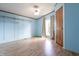 Light-filled bedroom featuring wood-look flooring and blue wall paneling at 4632 Willowbrook Dr, Columbus, IN 47203