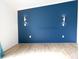 Bedroom with blue accent wall, decorative lighting, and wood-look flooring at 4632 Willowbrook Dr, Columbus, IN 47203