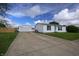 Property featuring a long driveway, detached garage, and a well-maintained one-story home at 4632 Willowbrook Dr, Columbus, IN 47203