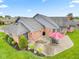 Aerial view of a brick home with green grass, patio and lush landscaping offering a private retreat at 4711 Bentley Dr, Carmel, IN 46033