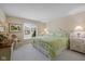 Bright bedroom featuring a comfortable bed with green bedding and a window with natural light at 4711 Bentley Dr, Carmel, IN 46033