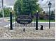 Elegant entrance to Brookshire Village featuring a decorative sign, wrought iron fence and landscaping at 4711 Bentley Dr, Carmel, IN 46033