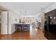 Open kitchen layout with hardwood floors, island seating, stainless steel appliances, and a view to the living room at 4711 Bentley Dr, Carmel, IN 46033