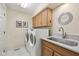 Functional laundry room featuring a washer, dryer, sink, and ample cabinet space at 4711 Bentley Dr, Carmel, IN 46033