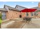 Brick home with a concrete patio, table, chairs, and umbrella perfect for outdoor entertaining at 4711 Bentley Dr, Carmel, IN 46033
