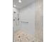 Modern walk-in shower with white tiling, a marble accent stripe, and a patterned tile floor at 4711 Bentley Dr, Carmel, IN 46033