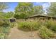 Well-maintained backyard with lush landscaping, stone exterior home and blue skies at 5005 Bonnie Brae St, Indianapolis, IN 46228
