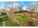 Landscaped backyard garden featuring a fire pit and a tranquil gazebo backdrop at 5005 Bonnie Brae St, Indianapolis, IN 46228