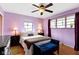 Tranquil bedroom with lilac walls, hardwood floors, and a blue accent bench at 5005 Bonnie Brae St, Indianapolis, IN 46228