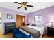 Charming bedroom with lilac walls, ceiling fan and hardwood floors at 5005 Bonnie Brae St, Indianapolis, IN 46228
