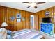 Wood paneled bedroom features colorful decor, a ceiling fan, and ample natural light at 5005 Bonnie Brae St, Indianapolis, IN 46228