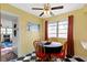 Bright kitchen area with a dining table, ceiling fan, and a large window with red curtains at 5005 Bonnie Brae St, Indianapolis, IN 46228
