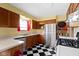 Well-lit kitchen featuring checkered floors, stainless appliances, and wooden cabinets at 5005 Bonnie Brae St, Indianapolis, IN 46228