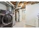 Basement laundry room featuring a black washer and dryer and water heater at 5254 Kingsley Dr, Indianapolis, IN 46220