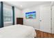 Relaxing bedroom features a wall-mounted TV, hardwood floors, and natural lighting at 5254 Kingsley Dr, Indianapolis, IN 46220