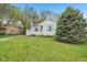 Charming single-story home featuring a manicured lawn, light siding, and bright blue shutters at 5254 Kingsley Dr, Indianapolis, IN 46220