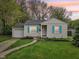 Charming single-story home featuring a manicured lawn, light siding, and bright blue shutters at 5254 Kingsley Dr, Indianapolis, IN 46220