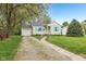 Charming single-story home featuring a manicured lawn, light siding, and bright blue shutters at 5254 Kingsley Dr, Indianapolis, IN 46220