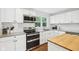 Well-lit kitchen showcasing white cabinetry, subway tile backsplash, and stainless steel oven and microwave at 5254 Kingsley Dr, Indianapolis, IN 46220