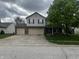 Charming two-story home featuring a large tree, a two-car garage and a well-manicured lawn at 5817 Jamestown Square Ln, Indianapolis, IN 46234