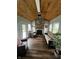 Cozy sunroom with a stone fireplace, wooden ceiling, and ample natural light at 5817 Jamestown Square Ln, Indianapolis, IN 46234