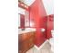 Bathroom with bright red walls, wood vanity and tiled floors at 5849 Wooden Branch Dr, Indianapolis, IN 46221