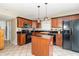 Well-lit kitchen featuring wooden cabinets, a center island, and black appliances at 5849 Wooden Branch Dr, Indianapolis, IN 46221
