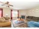 Cozy living room with warm color palettes, a fireplace, ceiling fan, and comfortable seating arrangements at 5849 Wooden Branch Dr, Indianapolis, IN 46221