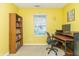 Cozy home office with bright yellow walls, a built-in bookshelf, and a computer desk at 5849 Wooden Branch Dr, Indianapolis, IN 46221