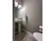 Powder room featuring a pedestal sink, mirror, towel ring, toilet, and ceramic tile flooring at 6040 Bluecrest Dr, Brownsburg, IN 46234