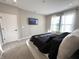 Sunlit bedroom with plush carpeting, light gray walls, and a wall-mounted television at 6040 Bluecrest Dr, Brownsburg, IN 46234