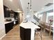 Bright kitchen boasts dark cabinets, stainless appliances, a quartz island and a view of the adjacent dining area at 6040 Bluecrest Dr, Brownsburg, IN 46234