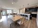 Open-concept living and dining area with hardwood floors, modern light fixtures, and kitchen island at 6040 Bluecrest Dr, Brownsburg, IN 46234